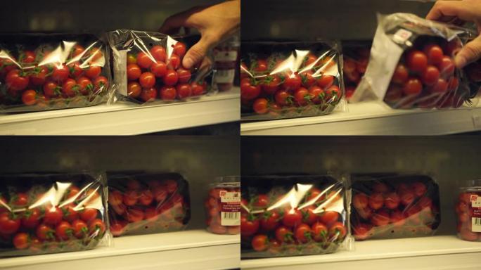 一名男子从商店货架上挑选樱桃番茄的特写镜头