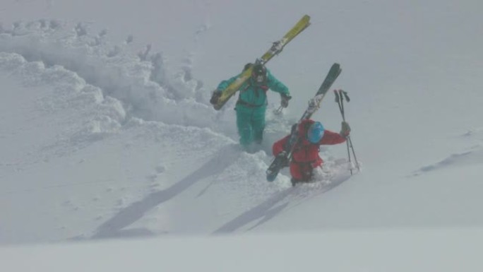 两名滑雪者在雪中跋涉的慢动作镜头