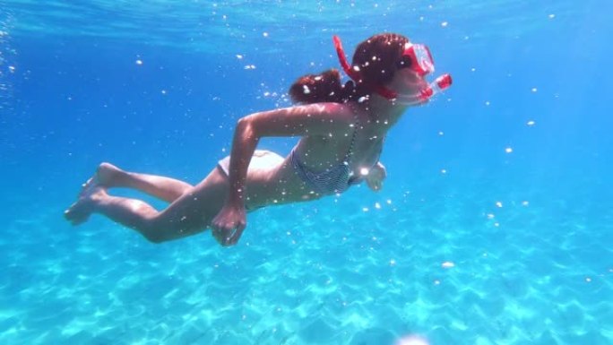 女人在海里浮潜。通过可穿戴相机游泳