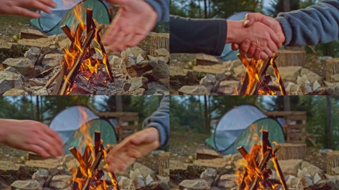 SLO MO两名男子在森林的篝火前握手