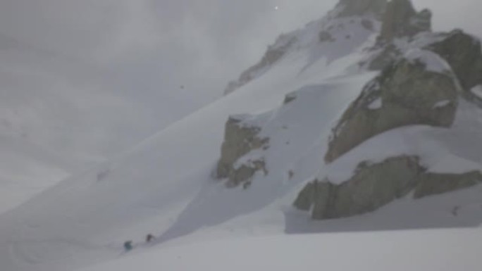 两名滑雪者在山坡上攀爬滑雪板