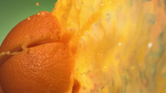 绿色自然背景下慢动作的新鲜橙色水果喷射果汁4K