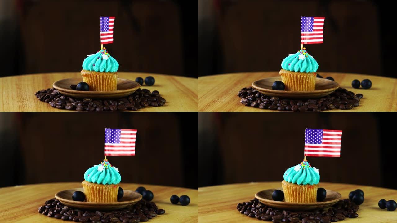 在带有美国国旗的旋转板上的一堆咖啡豆上的木盘中的美味纸杯蛋糕