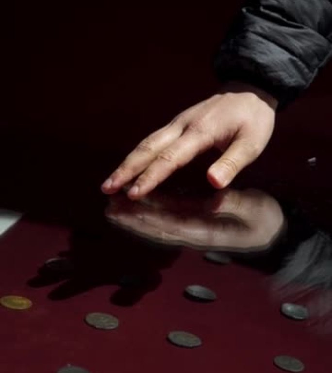 展示中一只手在古代硬币上奔跑的细节镜头