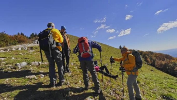 SLO MO POV一群徒步旅行者在阳光明媚的山顶上