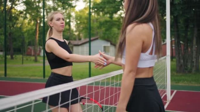 网球场上的女性对手，在比赛，训练或专业比赛前握手
