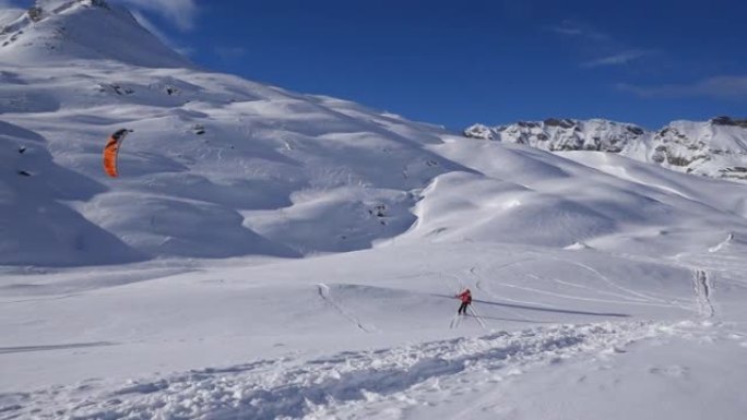 男子在雪山上脱下风筝冲浪