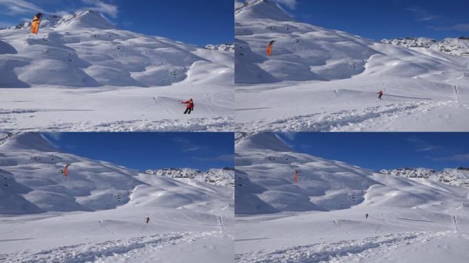 男子在雪山上脱下风筝冲浪