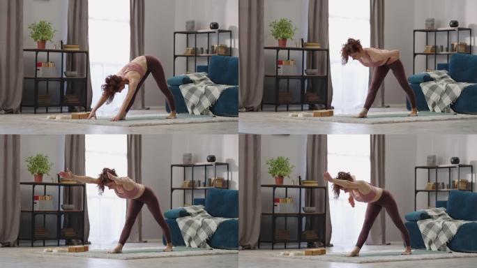 年轻苗条女人在家瑜伽锻炼，女士站在客厅训练，做静态体式