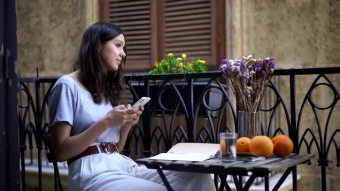 年轻女子用手机在阳台上发短信