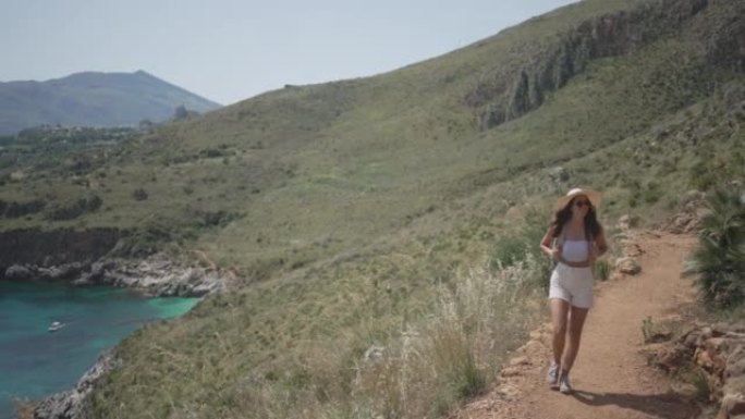 年轻女子在海边自然保护区的悬崖边徒步旅行