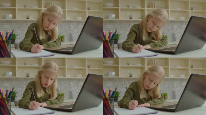 可爱的学龄聋哑女孩在笔记本电脑上学习在线课程并做作业