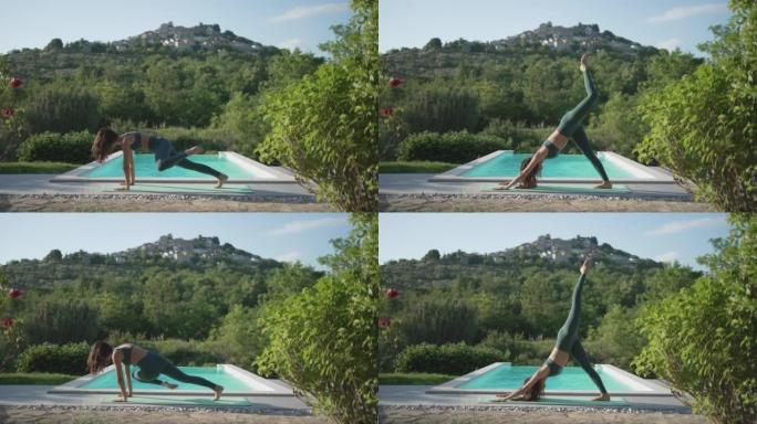 年轻女子在大自然的游泳池旁做瑜伽，俯瞰一个小村庄