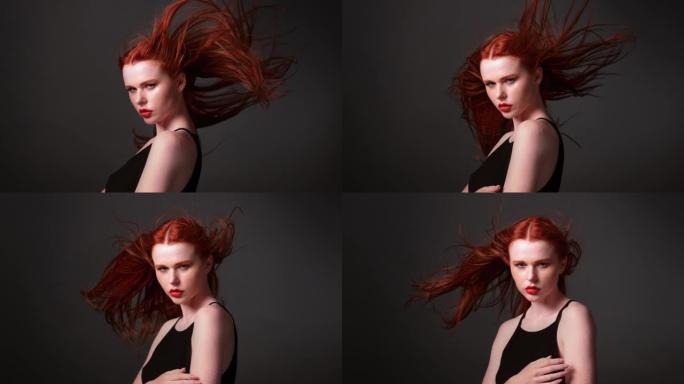 美丽的红发女人，长长的健康的头发在风中挥舞。诱人的脸