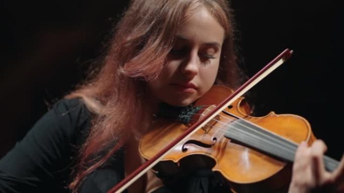 年轻的女提琴手正在爱乐音乐厅学习拉小提琴或中提琴