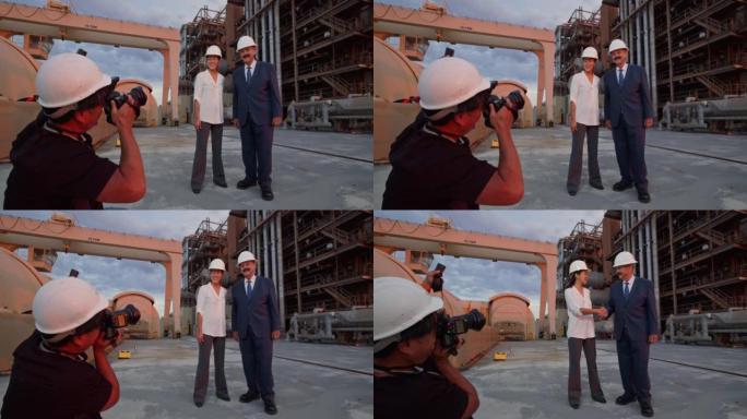 摄影师拍摄经理或政客在电厂外握手的照片
