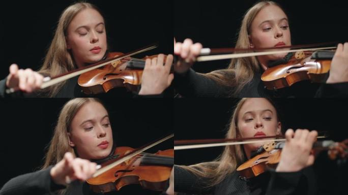 漂亮年轻的女提琴手在爱乐大厅拉小提琴或中提琴，肖像