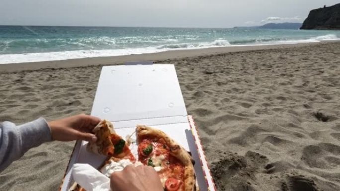年轻女子喜欢在海滩上吃披萨