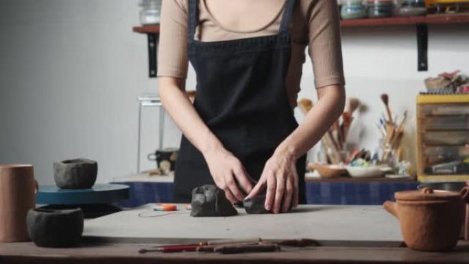 匿名年轻女子在陶艺工作室手工雕刻粘土。人准备产品用模具粘土。教育、商业、艺术天赋和创意手工制作的概念