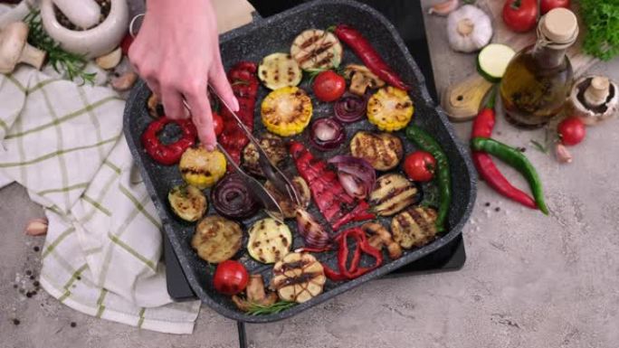 在家用厨房的烧烤煎锅中烹饪切成薄片的蔬菜