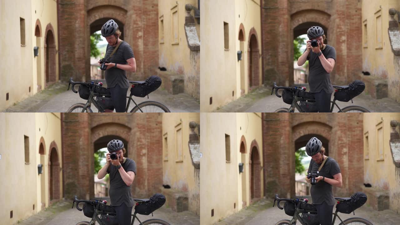 骑自行车的人停下来欣赏风景并在中世纪的小镇拍照