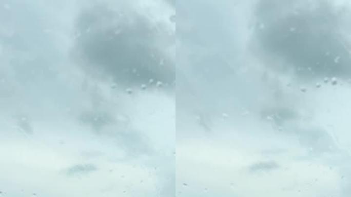 在阴天，在阿拉巴马州的65号州际公路上行驶时，雨滴在汽车挡风玻璃上划过的垂直视频