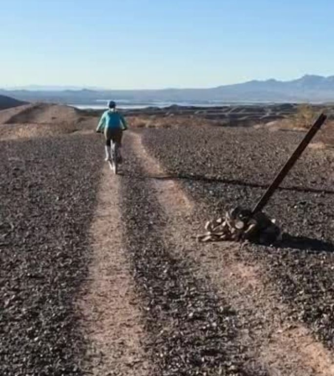 女性山地自行车手沿着沙漠小路