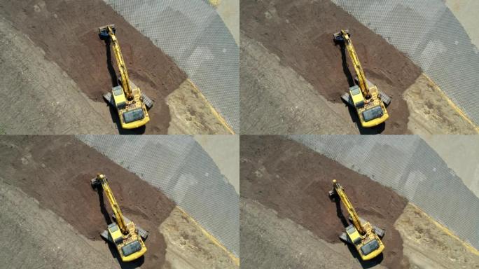 黄色挖掘机，带连续履带。鸟瞰图。右旋转摄像机移动。找平挖掘机。施工现场准备。不同的土壤层。填充挖掘机
