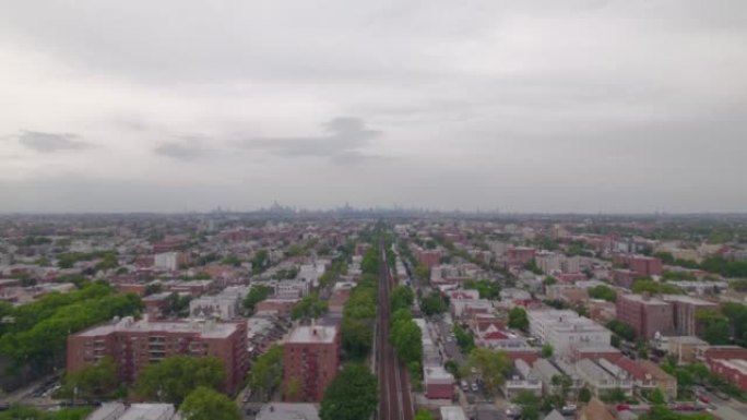火车在纽约布鲁克林的房屋之间行驶。火车上的鸟瞰图。无人驾驶飞机前往曼哈顿。