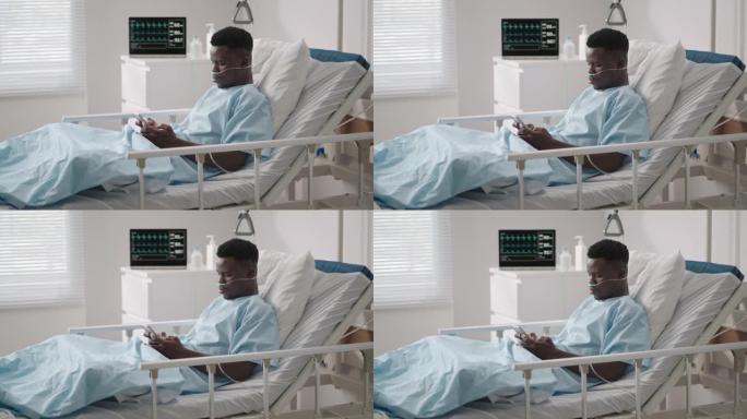 一名黑人男子躺在医院的病床上，从医院向他的朋友和亲戚提供信息。通过互联网和移动设备与医院中的亲人交流