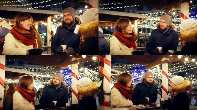 一群朋友在慢动作的下雪的圣诞节夜晚一起喝热巧克力