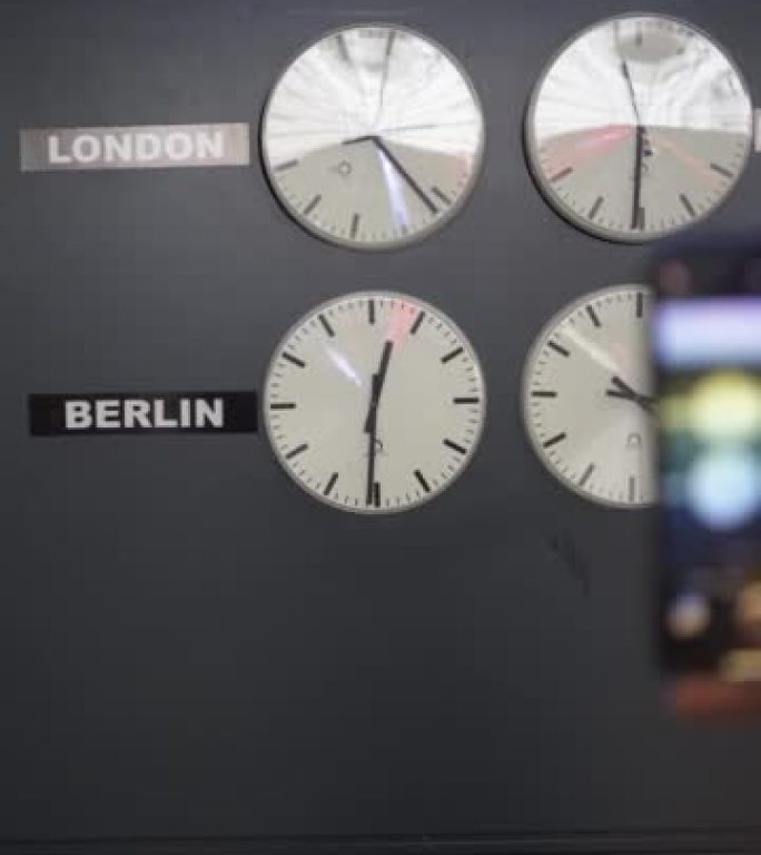 一名妇女在大型世界钟表前的机场拍照的垂直细节照片