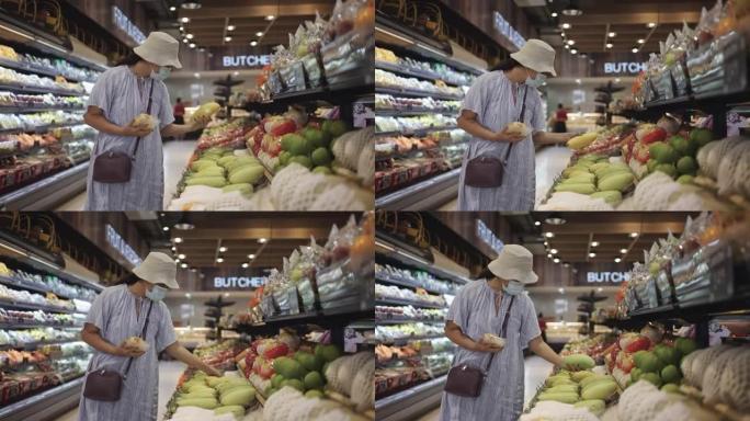 戴帽子和防护口罩的女人在超市购物