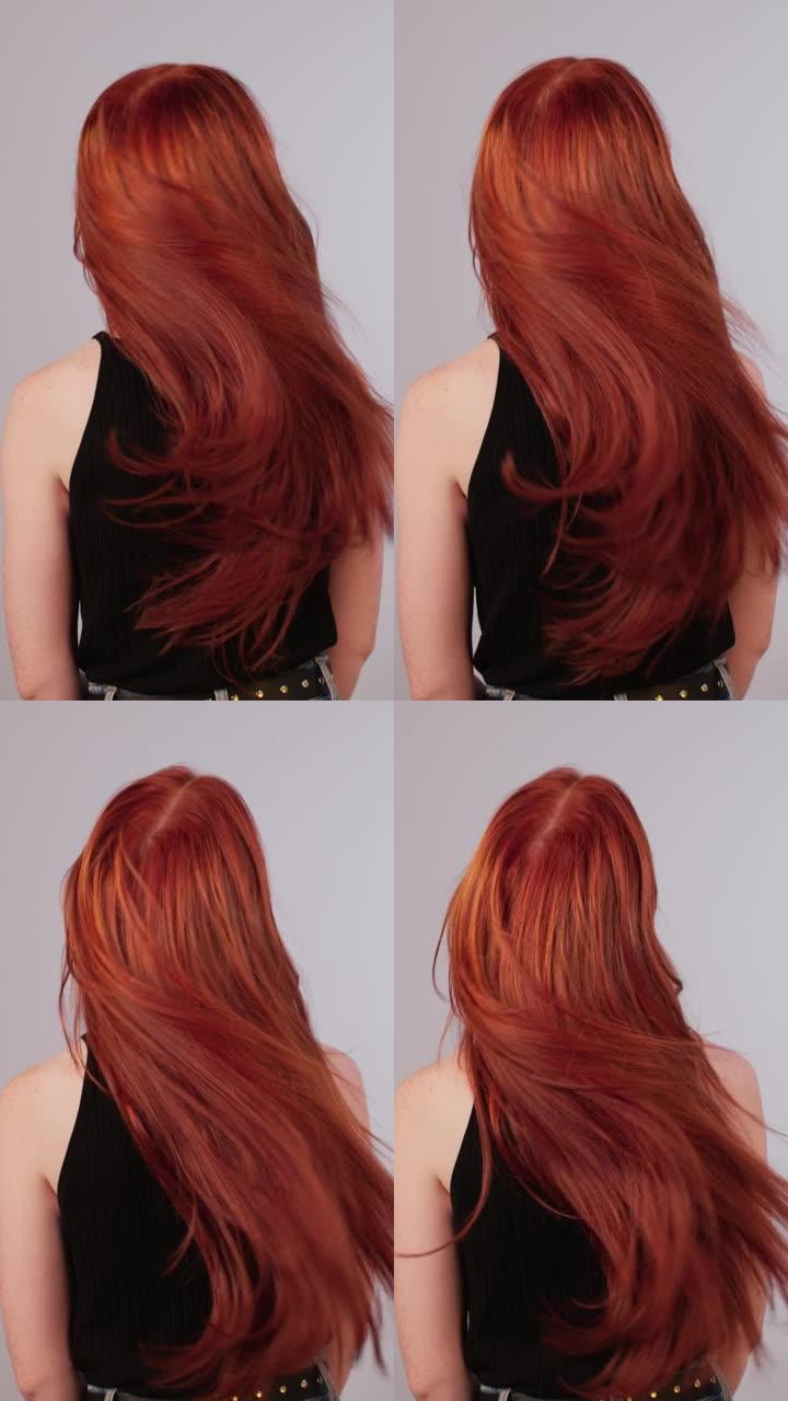 美丽诱人的红发女人扔长发。闪亮的红头发在镜头前移动