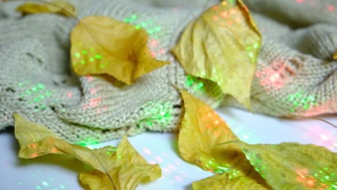 秋天的静静，落叶和窗台上的针织米色围巾，带有闪烁的花环灯。波西米亚风情与大气的秋意