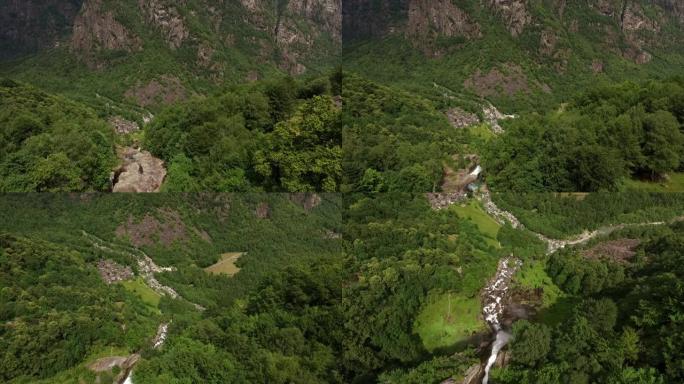 空中无人机拍摄了郁郁葱葱的山谷和河流中的陡峭瀑布
