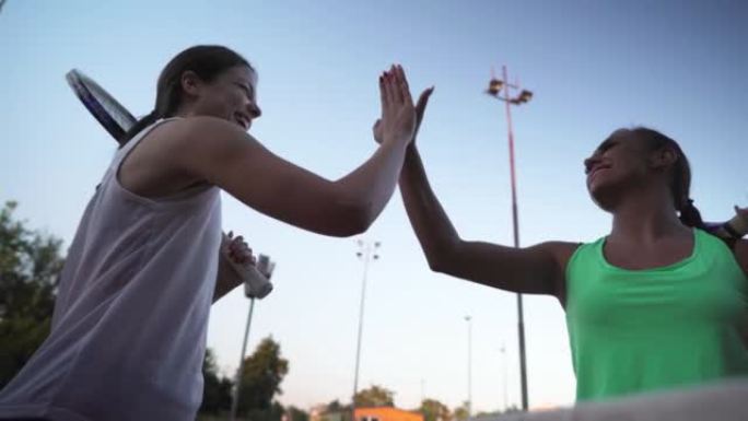 Two young adult female friends high five, after go