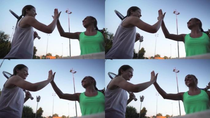 Two young adult female friends high five, after go