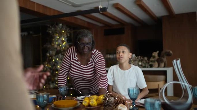 祖父母和孙子在家为圣诞节晚餐或午餐摆桌子