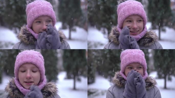 在户外下雪天，满足的白人少女温暖的双手在慢动作中摩擦手掌的头像。快乐的青少年享受冬季休闲微笑着看着远