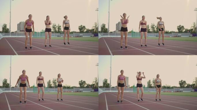 3名女子选手以慢动作准备在日落时在体育场进行长跑比赛