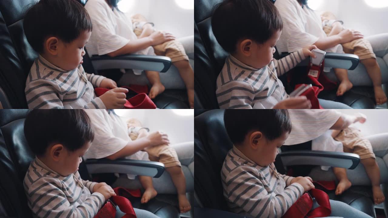 亚洲男孩在准备起飞的飞机上试图系好安全带