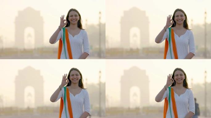 印度女孩在印度门显示“好的”标志