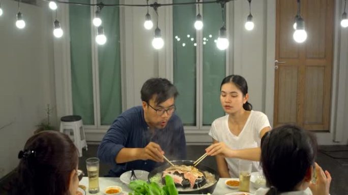 亚洲家庭吃泰国菜流行风格的派对，泰语中的 “猪肉锅” 正在将猪肉放在锅中烤