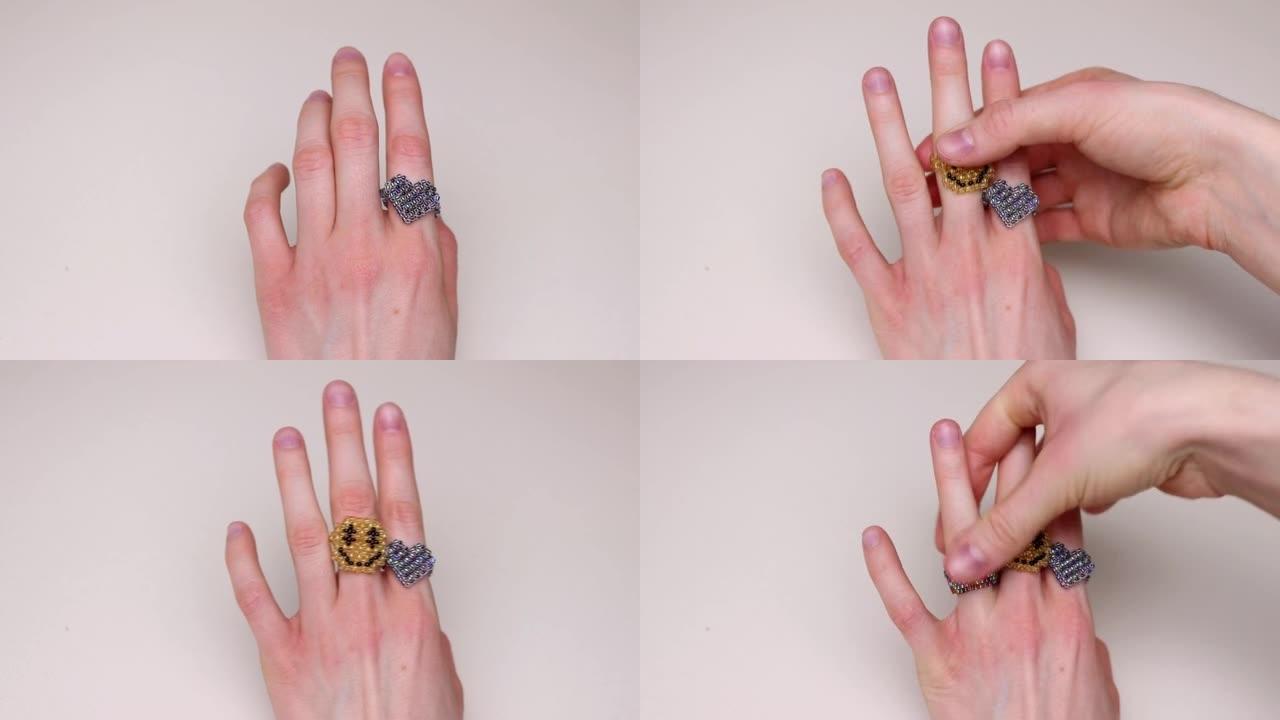 女性的手将珠子制成的戒指放在手指上。