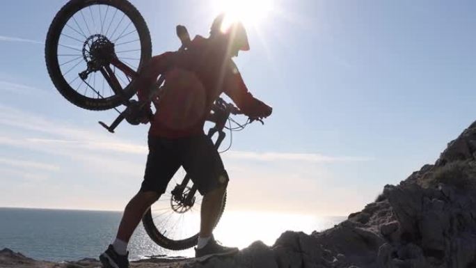 山地车手在攀登岩岭峰时携带自行车