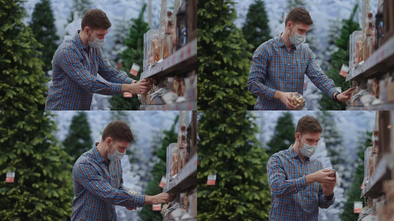 在大流行和检疫购物。一名男子在珠宝店戴着防护面具，花环上放着圣诞树和家里的玩具。圣诞花环和装饰。