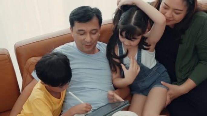 可爱的亚洲儿童与父母一起使用数字平板电脑玩游戏