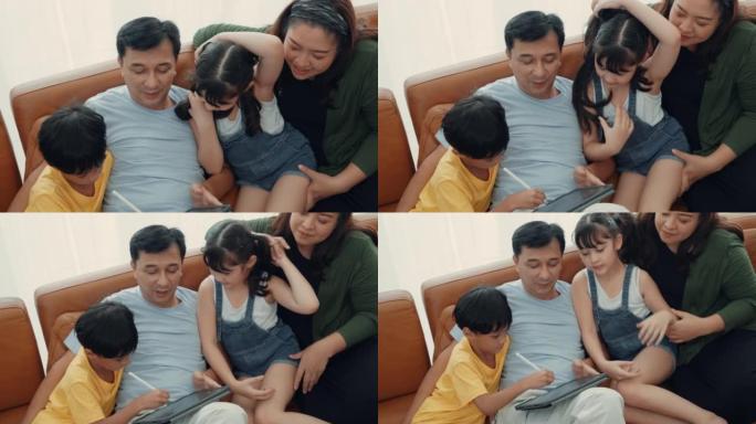 可爱的亚洲儿童与父母一起使用数字平板电脑玩游戏
