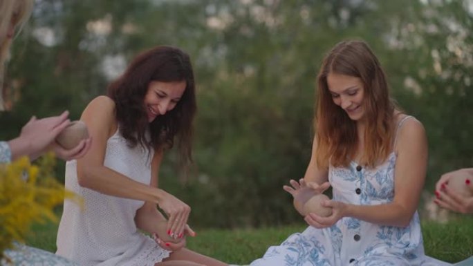一群年轻妇女正在用粘土雕刻，在大自然中，在田野中，在露天中大笑，交流。大师解释了正确的雕刻技术。创造
